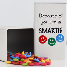 Load image into Gallery viewer, Ivory tin with black vinyl label and three smiley faces in red, blue and green - Because of you I'm a smartie with a picture of the tin with smartie chocolates