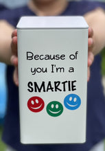 Load image into Gallery viewer, Ivory tin with black vinyl label with three smiley faces in red, green and blue - Because of you I'm a smartie with a picture of a child holding the tin