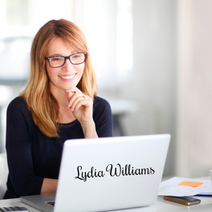 Picture of a lady at her work desk with a laptop with a laptop decal with the name Lydia Williams in black font