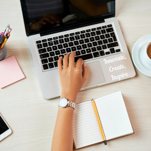 Picture of a laptop at a work desk with a laptop motto Innovate, Create, Inspire on the bottom right hand corner of the laptop in white font