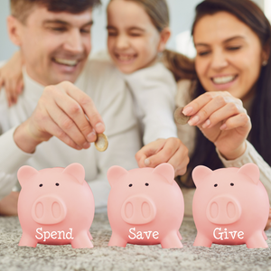 A family smiles while placing coins into three piggy banks labeled "Spend," "Save," and "Give.