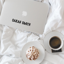 Load image into Gallery viewer, Picture of a laptop with a decal of the name Sarah Smith on a bed with a coffee and treat to eat
